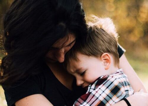 Enfant consolé, rassuré, dans les bras de sa maman